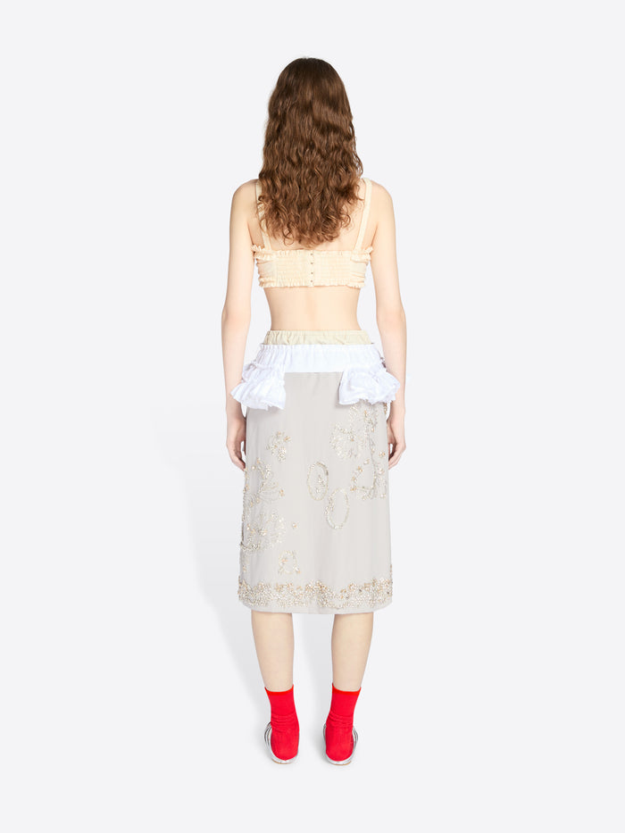 Woman wearing a beige lace top and skirt with red shoes on a white background - Dries Van Noten