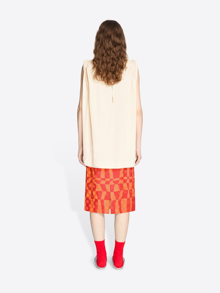 Person wearing a beige sleeveless top and red checkered skirt on a white background - Dries Van Noten