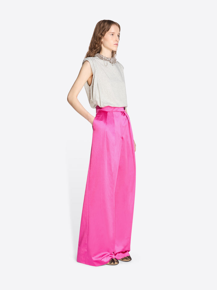 Woman wearing a light-colored sleeveless top and bright pink satin skirt on a white background - Dries Van Noten