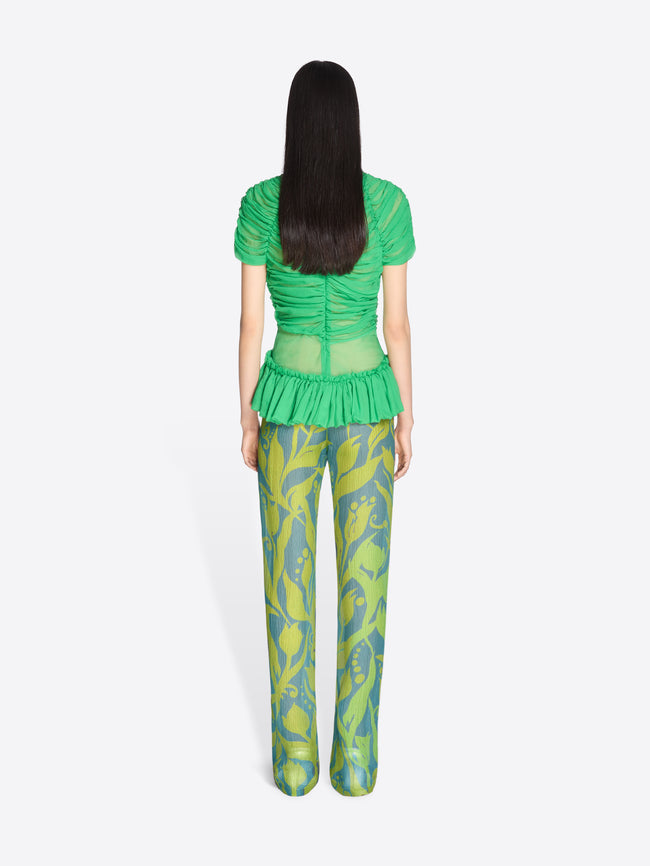 Person wearing a green top and patterned pants on a white background - Dries Van Noten