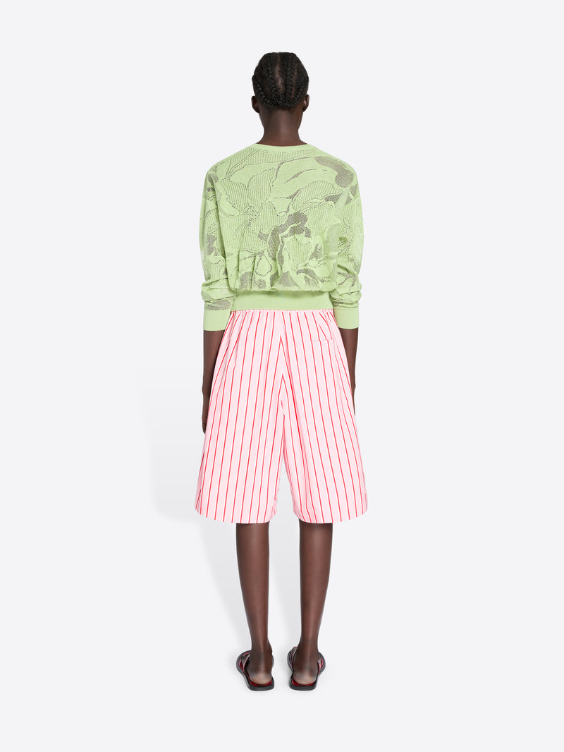 Person wearing a green patterned sweater and pink striped shorts on a white background - Dries Van Noten