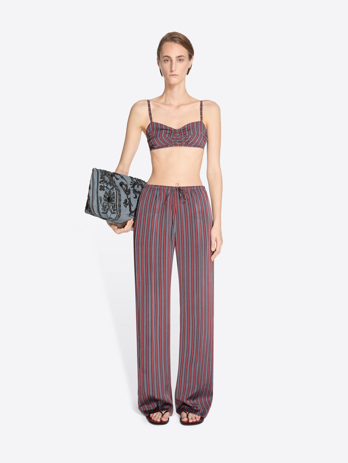 Woman wearing a striped outfit with a clutch on a white background - Dries Van Noten