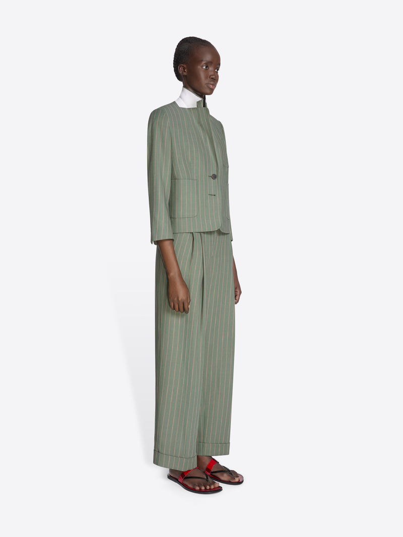 Person wearing a green pinstripe suit on a white background - Dries Van Noten