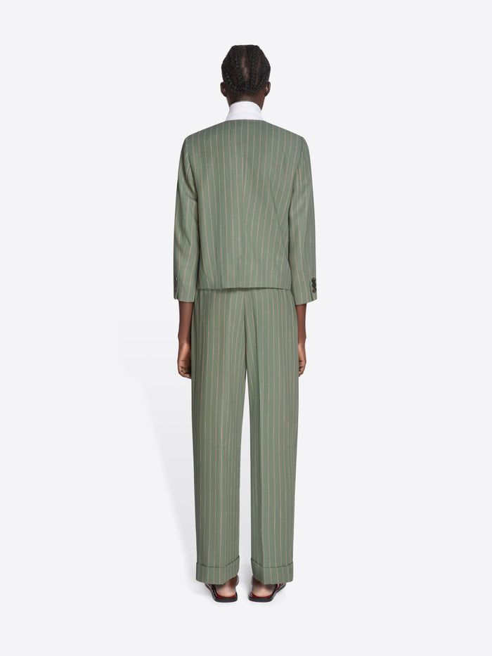 Person wearing a green pinstripe suit on a white background - Dries Van Noten