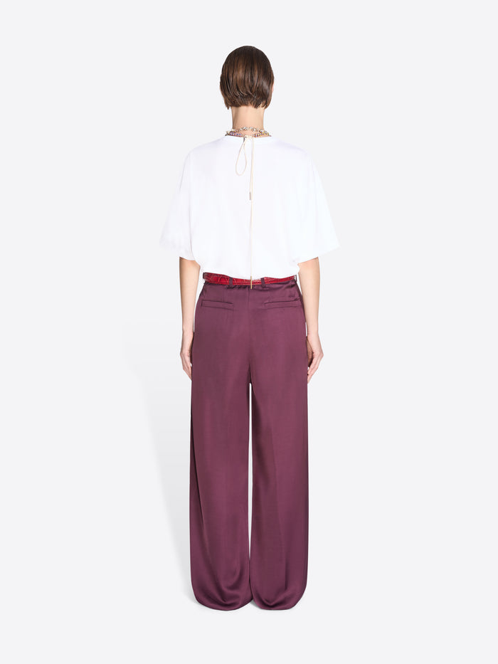 Person wearing a white blouse and purple pants on a white background - Dries Van Noten