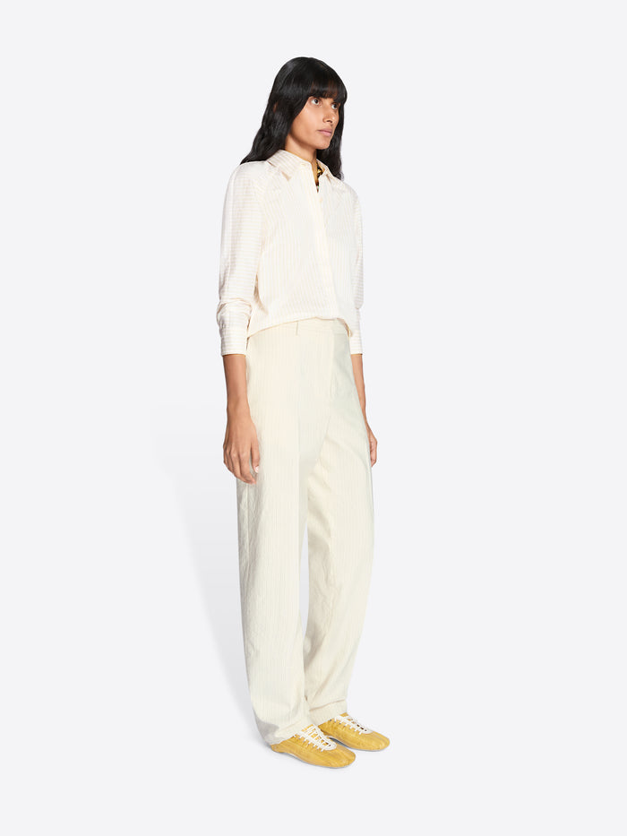 Woman wearing a white shirt and pants with yellow shoes on a white background - Dries Van Noten