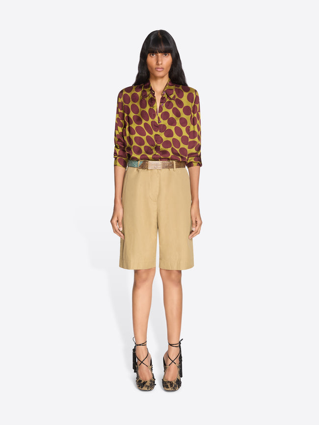 Woman wearing a patterned blouse and beige shorts on a white background - Dries Van Noten