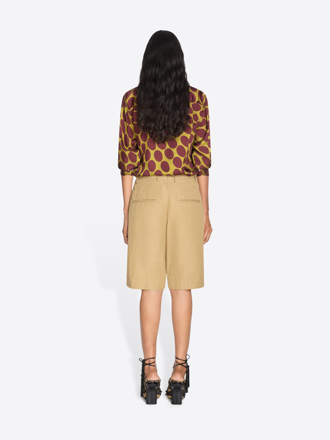 Woman wearing a patterned top and beige skirt on a white background - Dries Van Noten