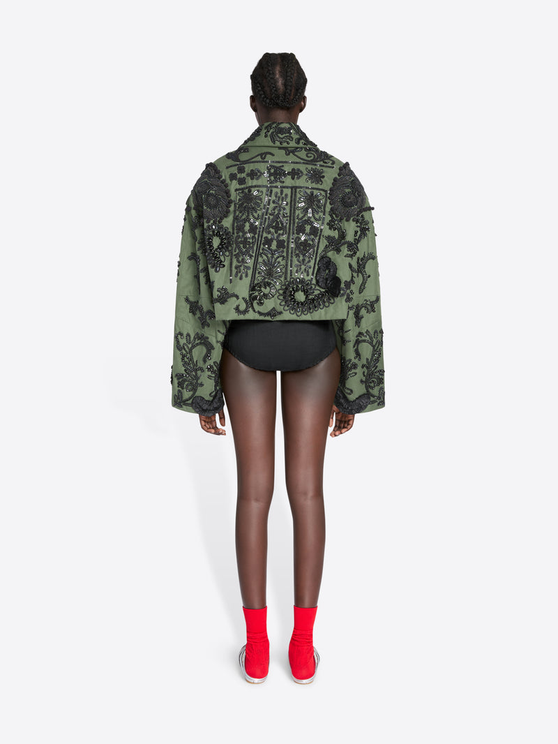 Person wearing a green embroidered jacket on a white background - Dries Van Noten