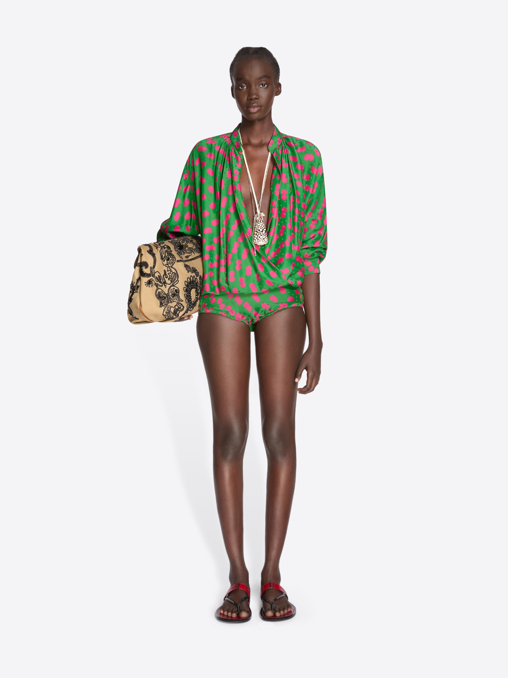 Model wearing a green and red patterned outfit with a handbag on a white background - Dries Van Noten