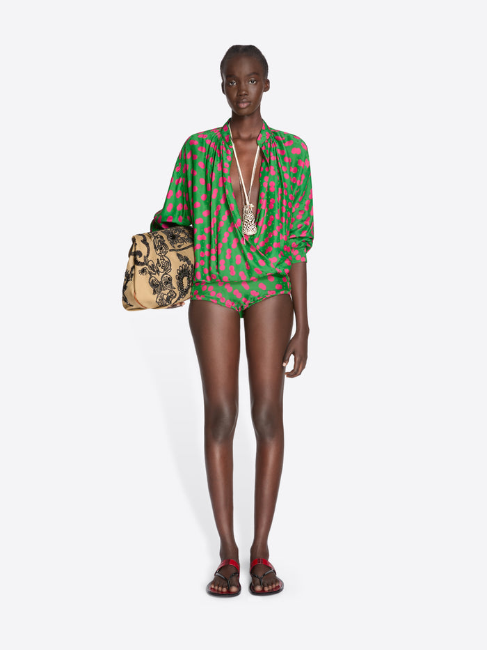 Model wearing a green and red patterned outfit with a handbag on a white background - Dries Van Noten