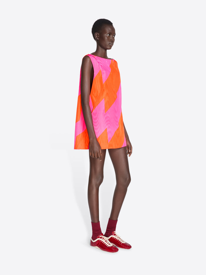 Model wearing a sleeveless dress with pink and orange geometric pattern on a white background - Dries Van Noten
