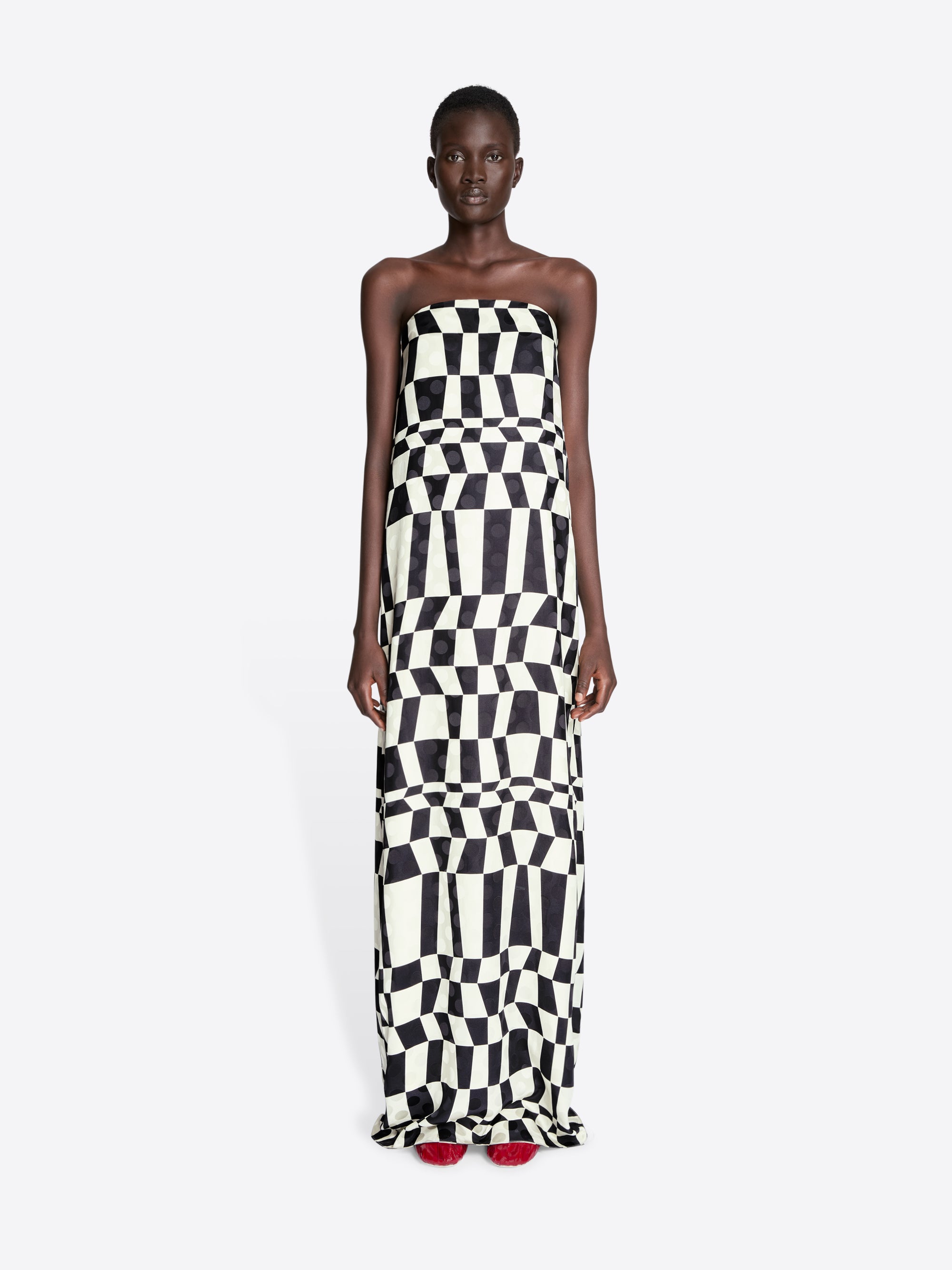 Model wearing a strapless dress with black and white geometric pattern on a white background - Dries Van Noten