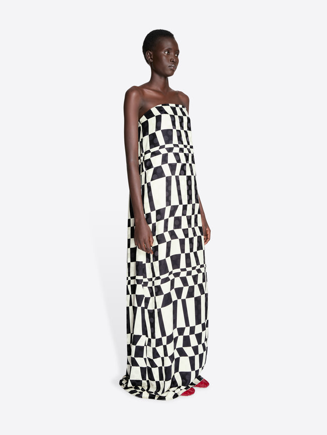 Model wearing a strapless dress with a black and white checkered pattern on a white background - Dries Van Noten