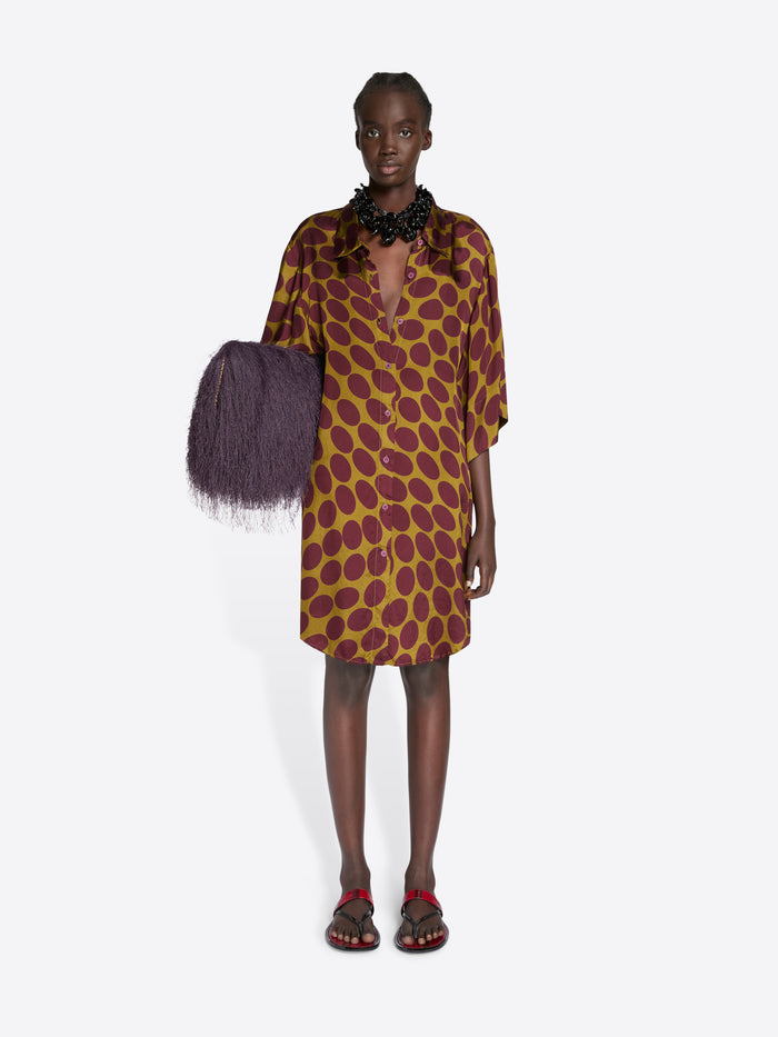 Model wearing a patterned dress with a purple bag on a white background - Dries Van Noten