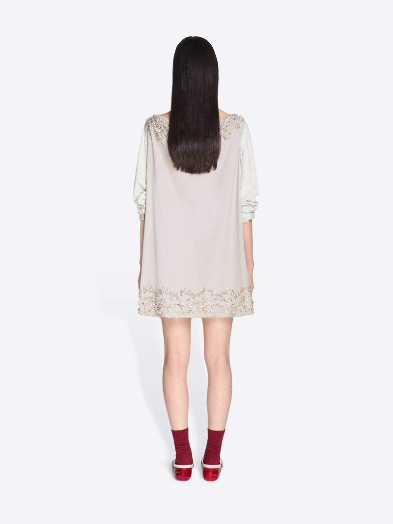Person wearing a white dress with lace details on a white background - Dries Van Noten