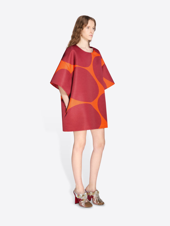 Model wearing a red and orange patterned dress on a white background - Dries Van Noten