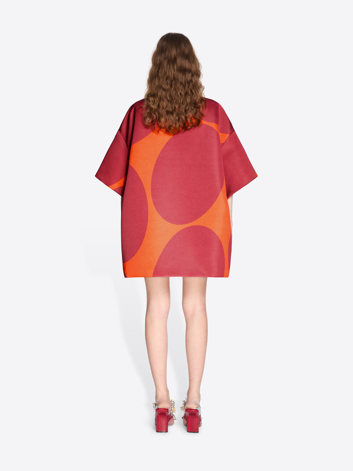 Woman wearing a red and orange patterned dress on a white background - Dries Van Noten