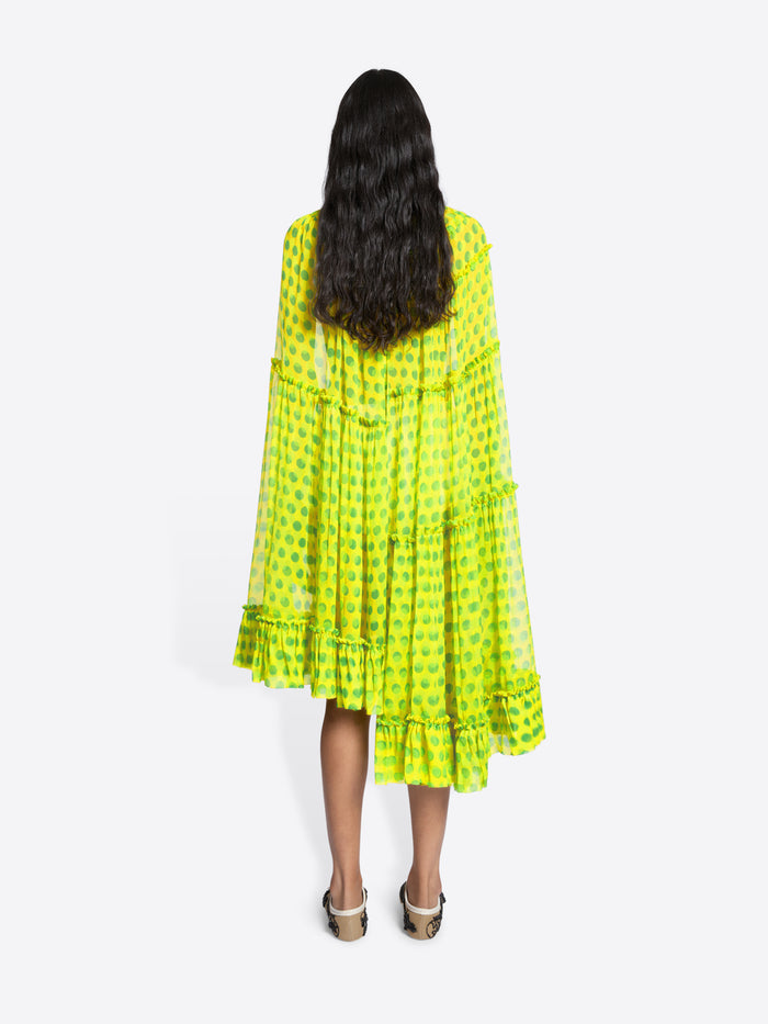 Person wearing a bright yellow dress with a pattern on a white background - Dries Van Noten