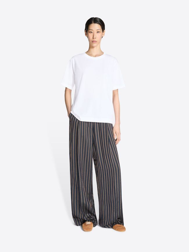 Person wearing a white t-shirt and striped pants on a white background - Dries Van Noten