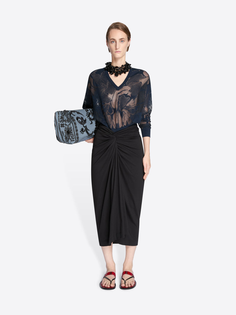 Model wearing a black lace top and black skirt holding a matching handbag on a white background - Dries Van Noten
