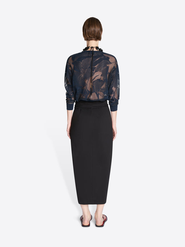 Person wearing a sheer black floral top and black pencil skirt on a white background - Dries Van Noten