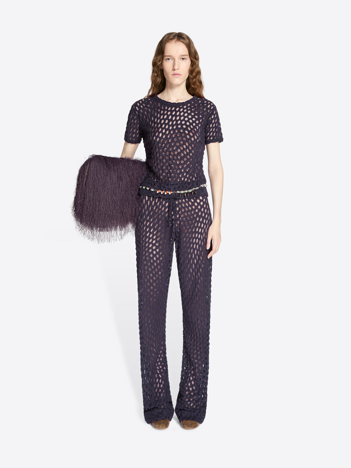 Woman wearing a dark purple fishnet outfit on a white background - Dries Van Noten