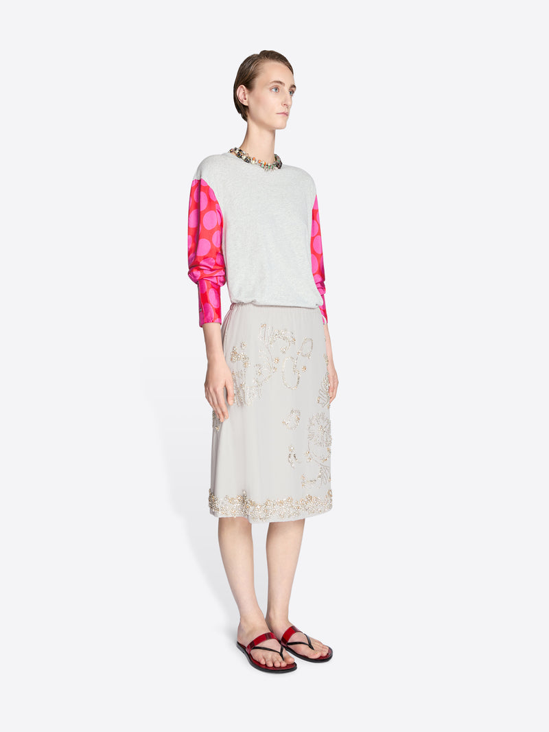 Woman wearing a white top with pink polka dots and a beige lace skirt on a white background - Dries Van Noten