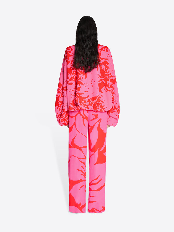 Person wearing a bright pink and red floral outfit on a white background - Dries Van Noten