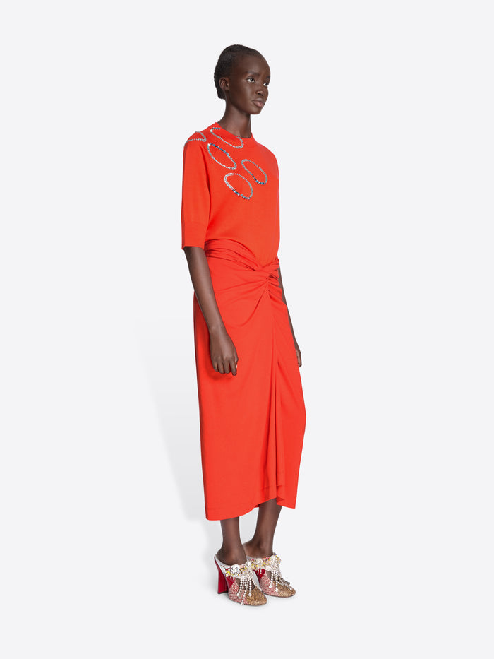 Woman wearing an orange dress with a pattern on a white background - Dries Van Noten