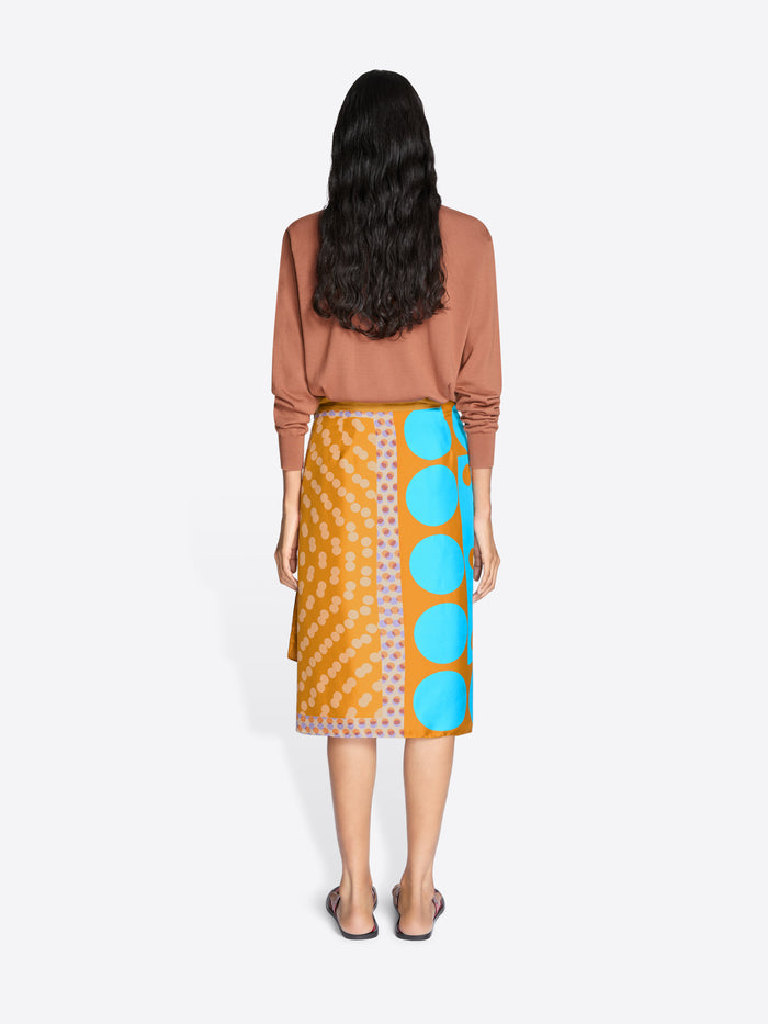 Woman wearing a patterned skirt with blue circles on a white background - Dries Van Noten
