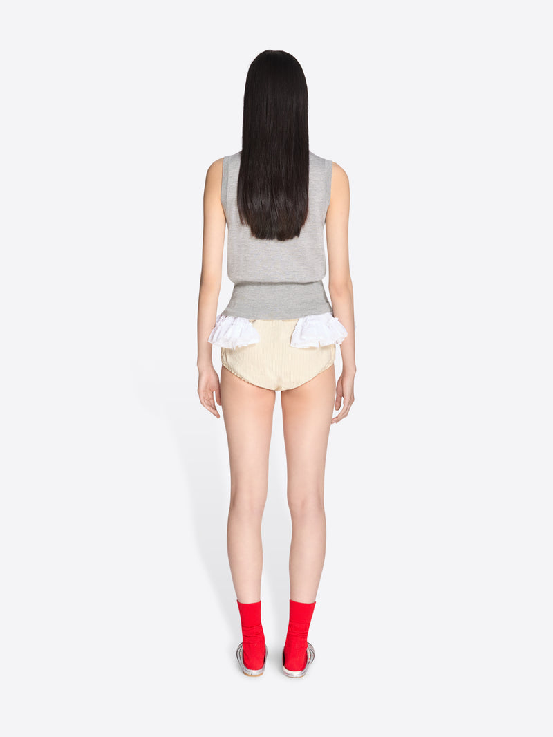 Person wearing a gray sleeveless top and beige shorts on a white background - Dries Van Noten