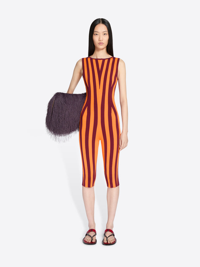 Model wearing a sleeveless orange and red striped jumpsuit on a white background - Dries Van Noten