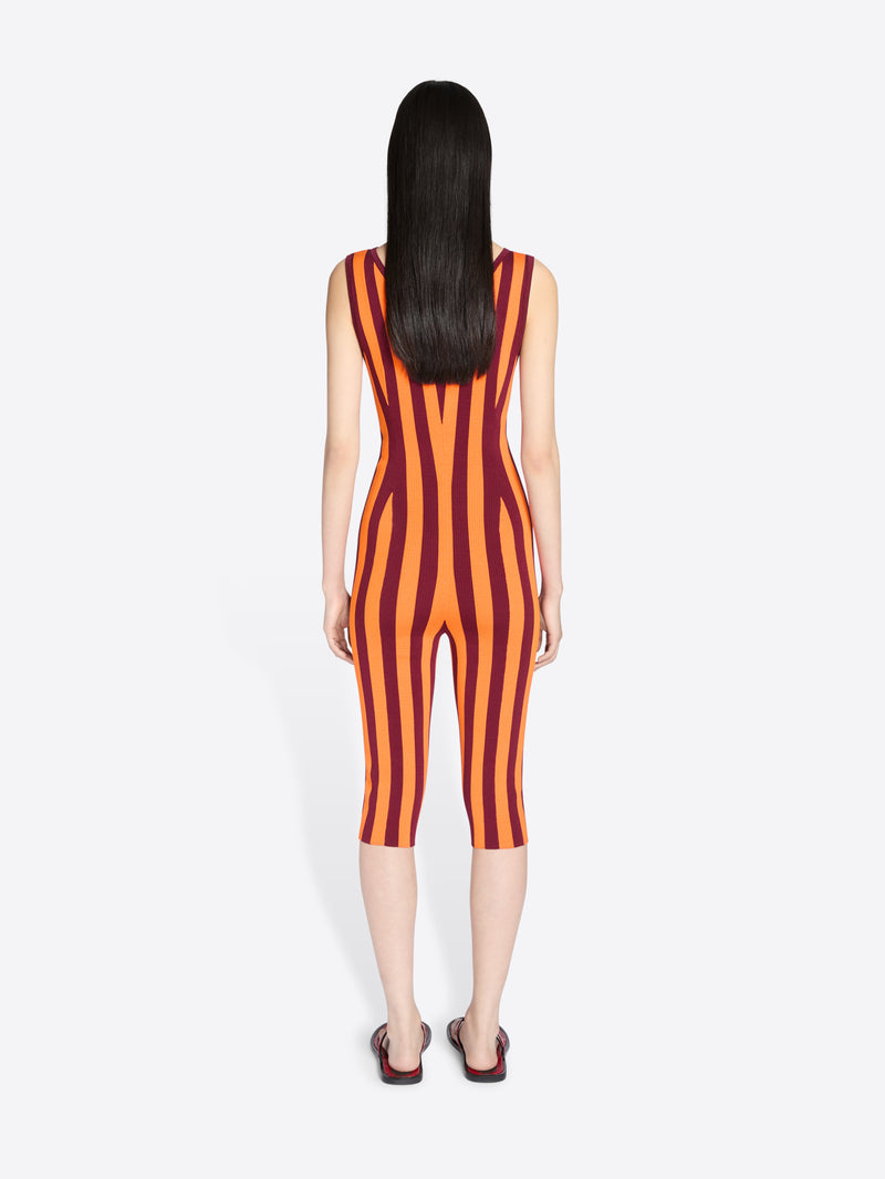 Person wearing a red and orange striped jumpsuit on a white background - Dries Van Noten