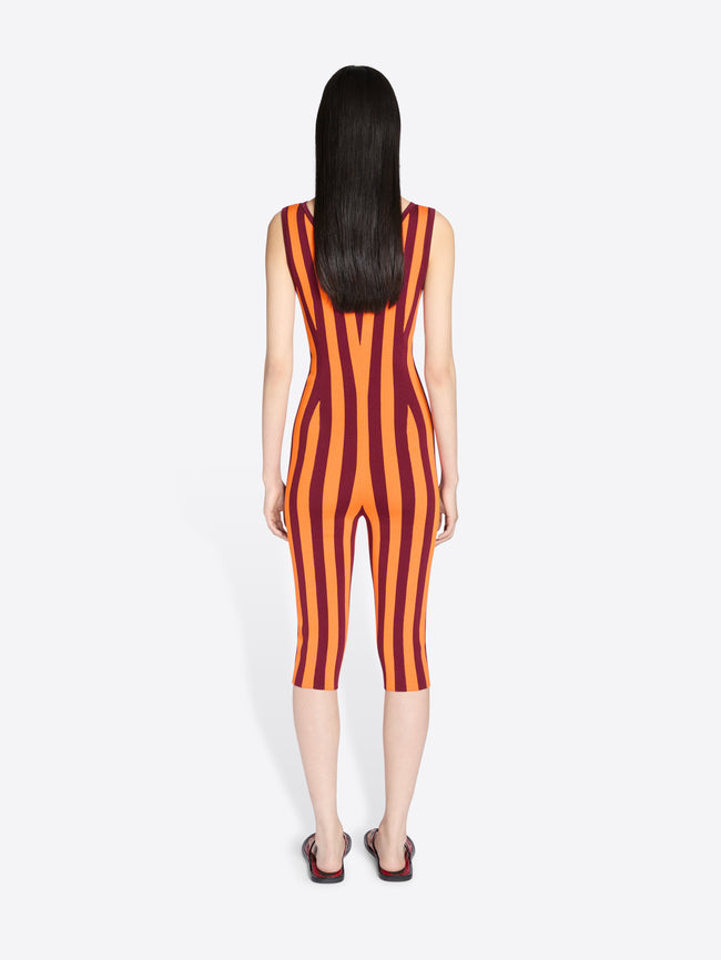 Person wearing a red and orange striped jumpsuit on a white background - Dries Van Noten