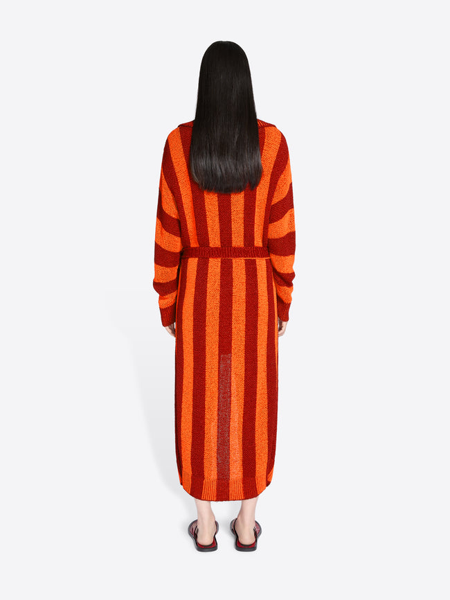 Person wearing a long orange and red striped dress on a white background - Dries Van Noten