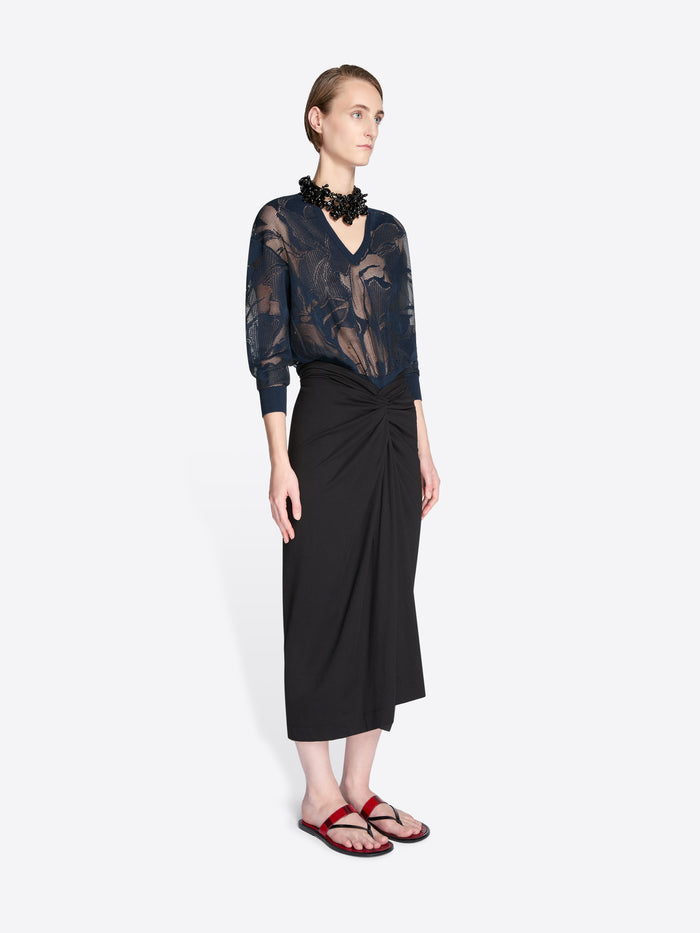Woman wearing a black lace top and black skirt on a white background - Dries Van Noten
