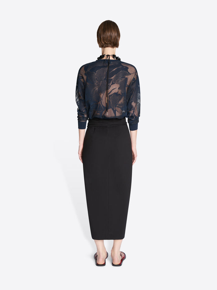Person wearing a sheer black floral blouse with a black pencil skirt on a white background - Dries Van Noten