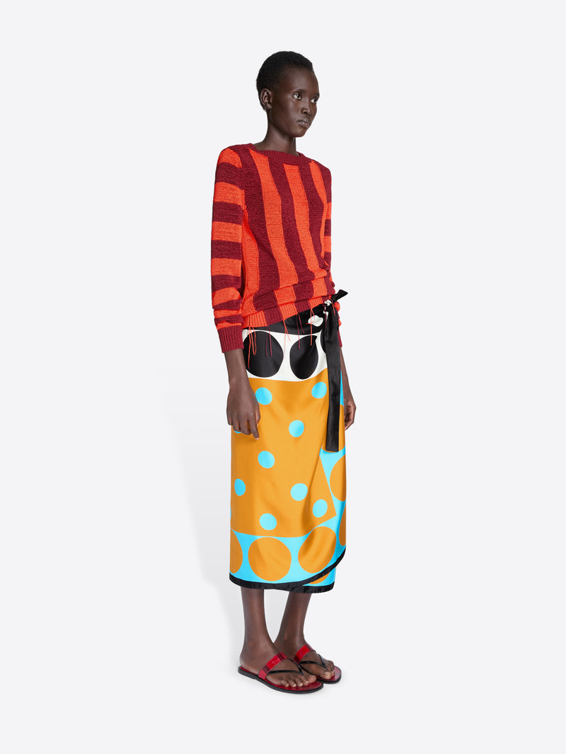 Model wearing a red and orange striped top with a colorful skirt on a white background - Dries Van Noten