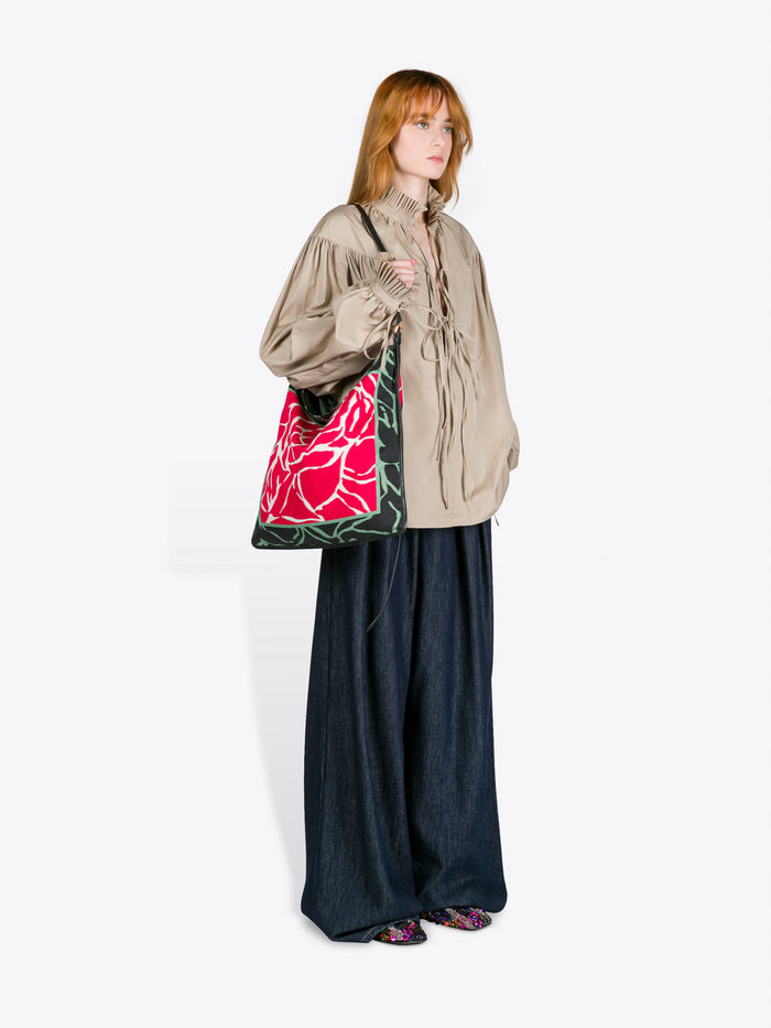 Person holding a floral-patterned bag against a white background - Dries Van Noten