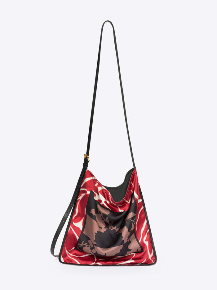 Red and black patterned bag with a strap on a white background - Dries Van Noten