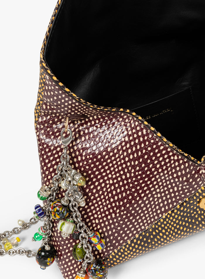 Close-up of a brown textured handbag with colorful charm chain on a white background - Dries Van Noten