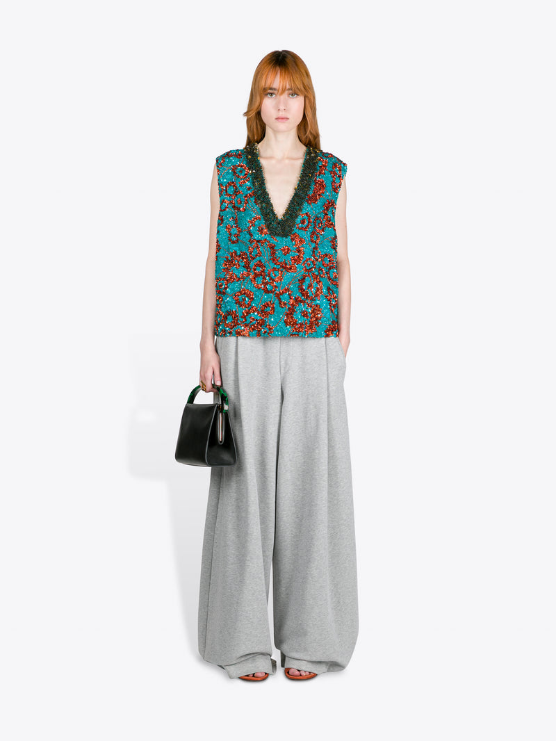 Woman wearing a sleeveless floral top and wide-leg pants on a white background - Dries Van Noten