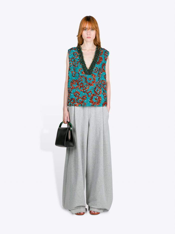Woman wearing a sleeveless floral top and wide-leg pants on a white background - Dries Van Noten