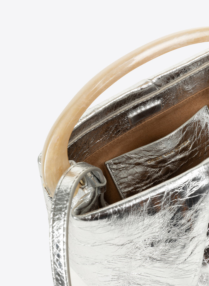 Close-up of a silver handbag with a beige handle on a white background