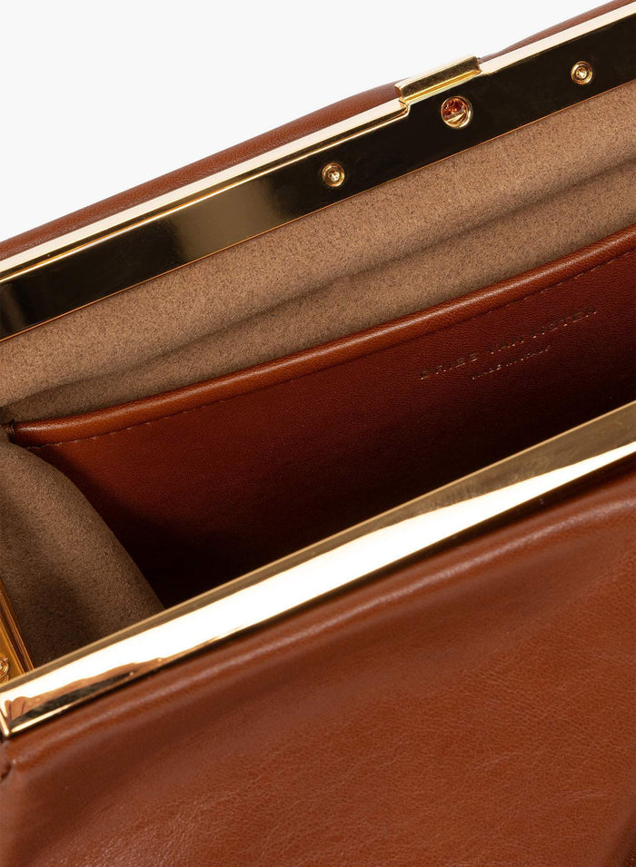 Close-up of a brown leather clutch with gold trim - Dries Van Noten