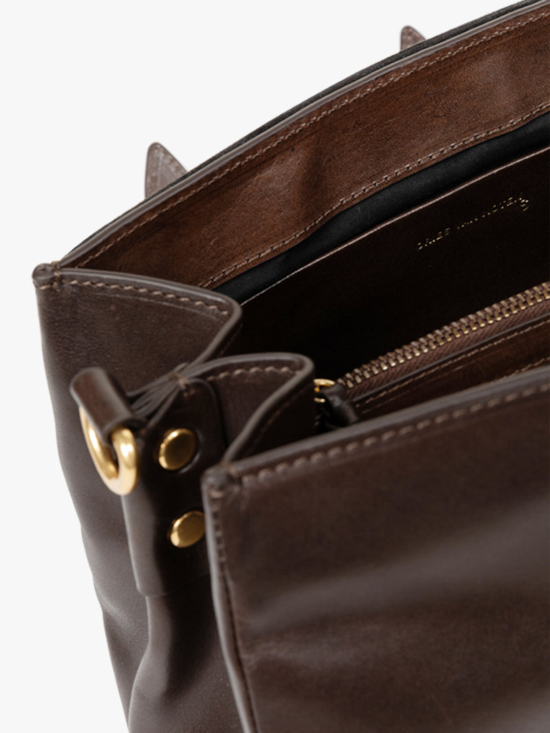 Brown leather bag with gold hardware on a white background - Dries Van Noten