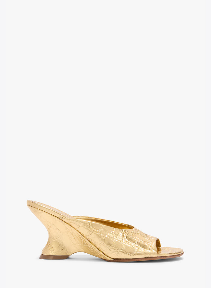 Gold open-toe shoe on a white background
