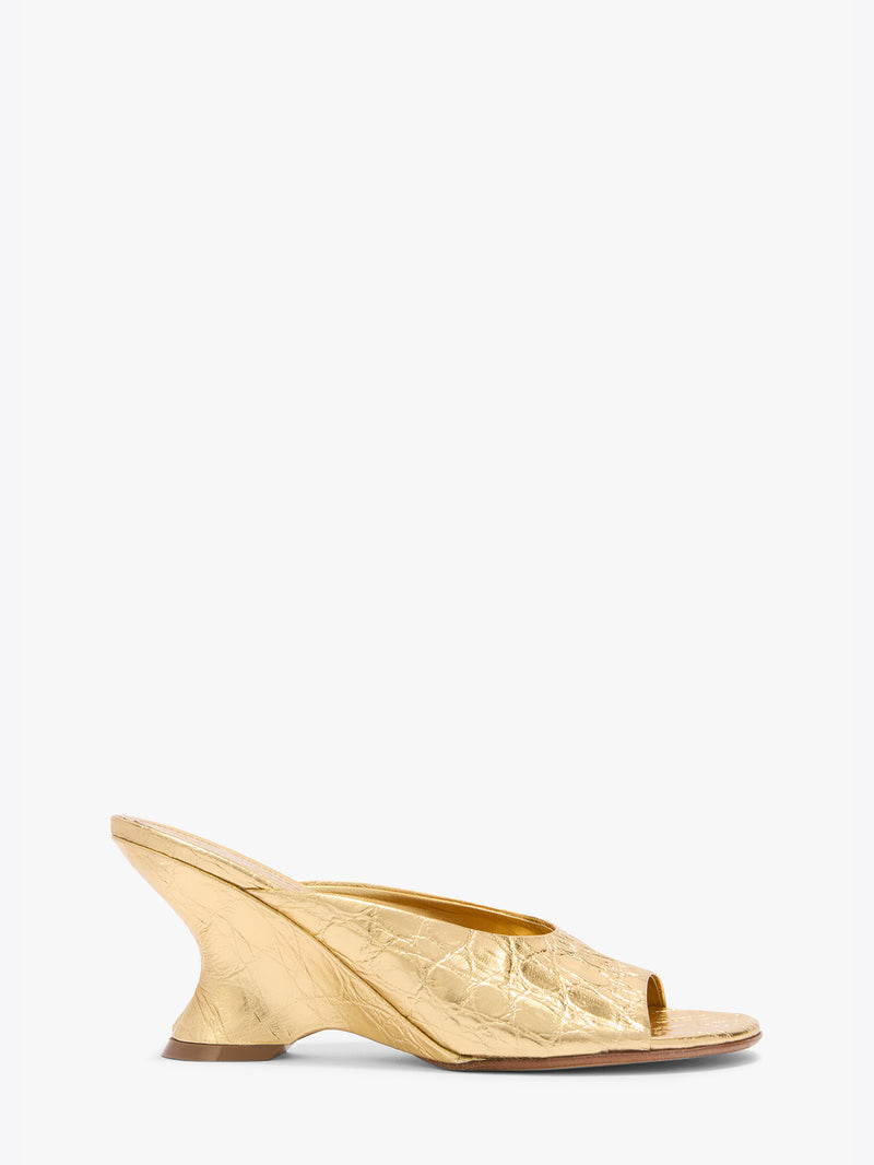 Gold open-toe shoe on a white background