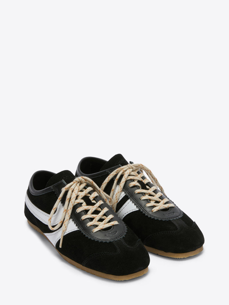 Pair of black and white sneakers with brown laces on a white background